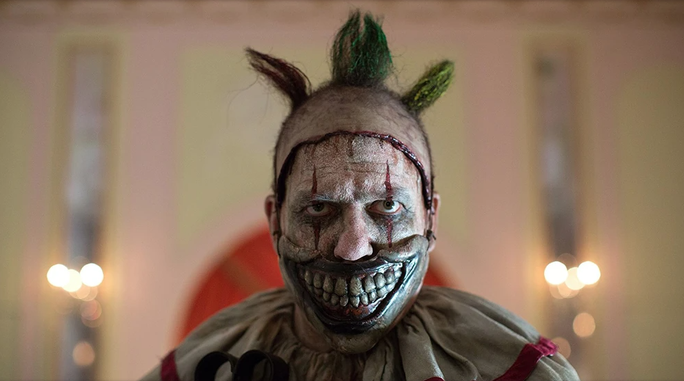 Twisty le Clown de American Horror Story, avec son masque terrifiant cachant sa mâchoire.