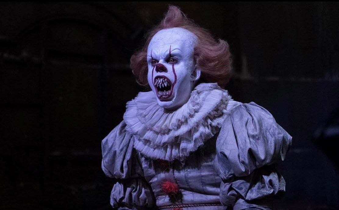 Grippe-Sou le Clown Dansant du film Ça, avec un regard perçant et un sourire menaçant.
