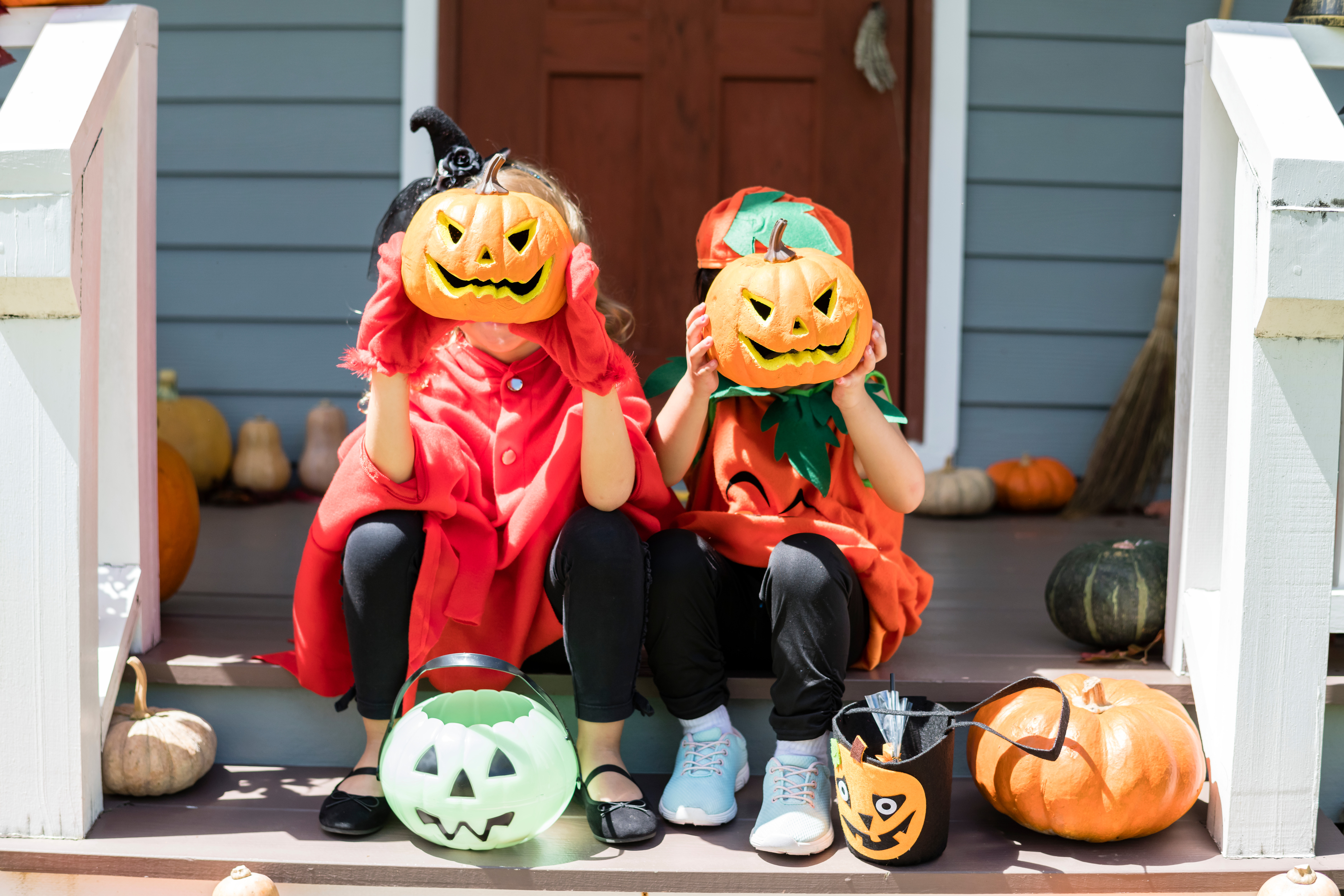 Children holding pumpkins to their faces.