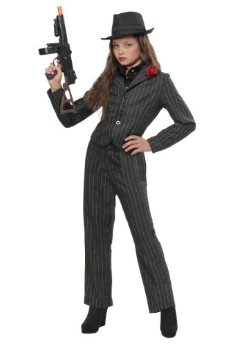 a girl dressed as a gangster in a black pinstripe suit with a red rose on the lapel, a black fedora, and black shoes, while holding a fake gun