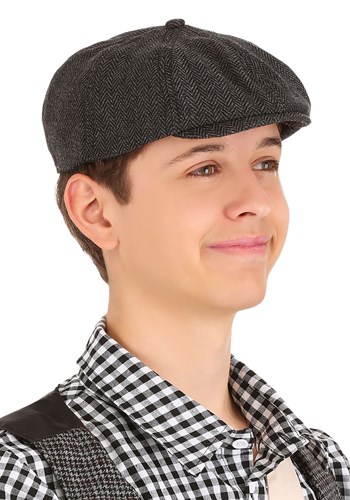 a boy wearing a newsboy cap